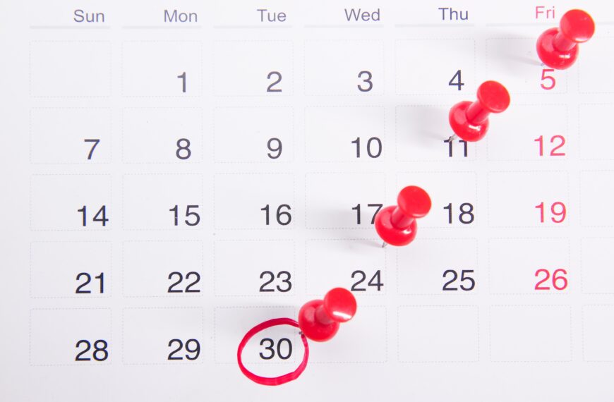 Gambar kalendar dengan tanggal merah yang ditandai dengan lingkaran dan pin